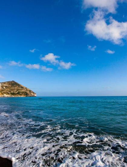 Spiaggia serena con mare azzurro e cielo limpido, trasmette pace e libertà.